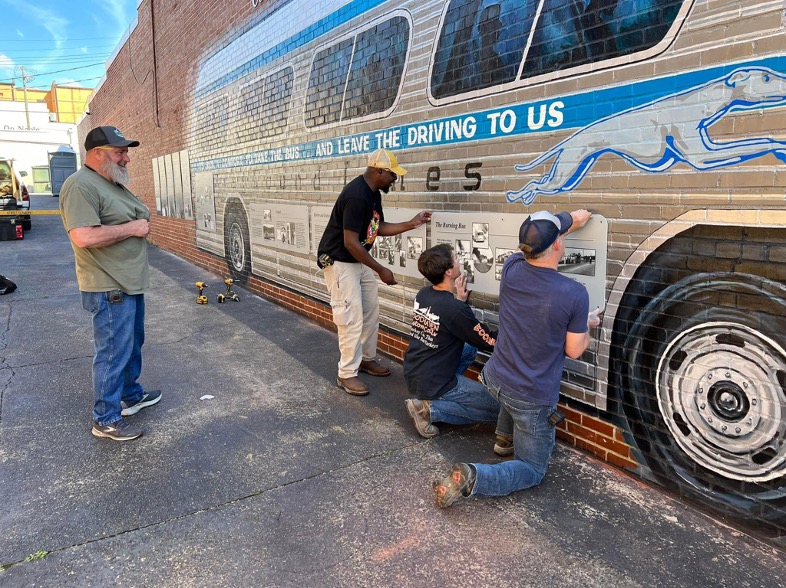 men installing the freedom rider monument downtown anniston alabama